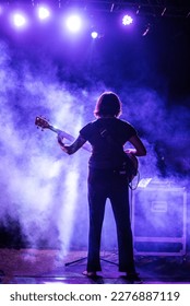 woman guitarist performing with lights and smoke