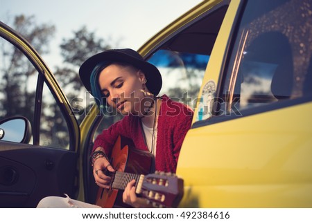 Woman guitarist playing music outdoors