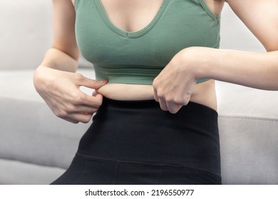 Woman in a gym clothes uses a centimeter strap to measure her circumference thin waist, Thin waist female, Health care concept and weight control, Sports waist, Healthy lifestyle, Physical activity.