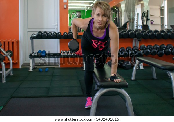 Woman Gym Does Dumbbell Lifts While Royalty Free Stock Image