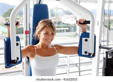 Woman At The Gym Doing Arms Exercises On A Machine