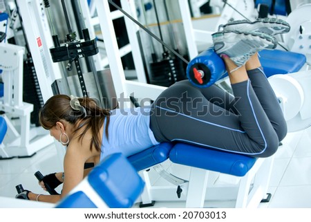 woman at the gym doing back exercises on a machine