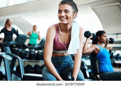 Woman, gym and thinking with towel, earphones and excited for results in training or fitness. Female person, happy and positive for wellness, health or exercise in rest, workout for strong muscle - Powered by Shutterstock