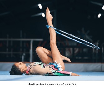 Woman, gymnastics and spinning hoop on leg for competition, sports training and action in arena. Female dancer, rhythmic movement and athlete with loop for creative solo concert, event or performance - Powered by Shutterstock