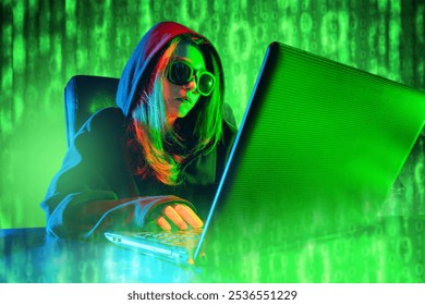 Woman hacker. Girl programmer. Hacker uses laptop to hack internet network. Green binary code behind geek. Woman programmer in hood. Lady in sunglasses. Hacker creates malware. System administrator