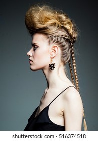 Woman With Hair Up In High Fashion Mohawk Look And Thin Braids Wearing Black Jump Suit.