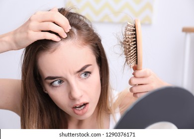 Woman with hair loss problem looking in mirror
