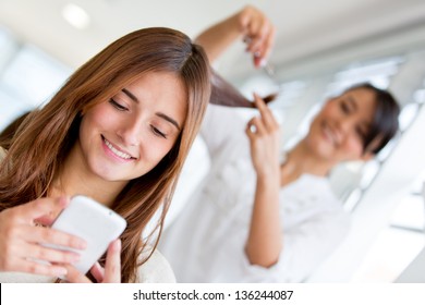 Woman At The Hair Salon Texting On Her Phone