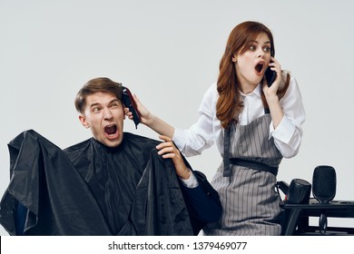 Woman Hairdresser Talking On The Phone And Making A Haircut For A Man Distracting From Work