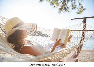 Woman In A Hammock With Book On Summer Day