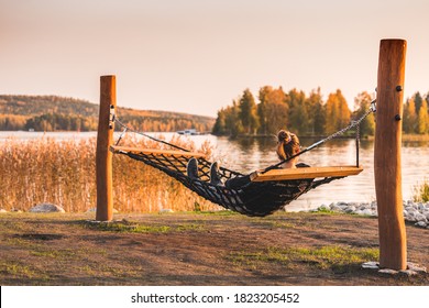 Woman In A Hammock Looking To A Autumn Lake