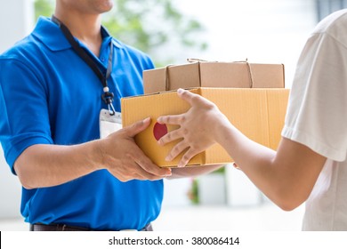 Woman hand accepting a delivery of boxes from deliveryman - Shutterstock ID 380086414