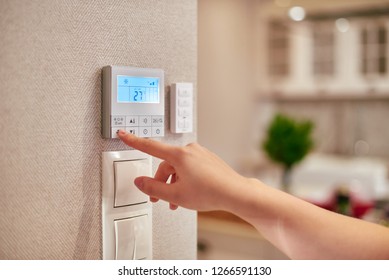 Woman hand adjusting temperature / thermostat