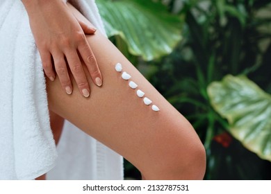 Woman Hand Is Applying Cream On Leg Skin From Cellulite In Spa. Body Care.