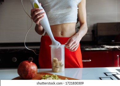 Woman With Hand Blender Making Sweet Banana Protein Powder Milkshake Smoothie. Protein Shake After Workout. Sport Nutrition Diet After Gym. Healthy Lifestyle