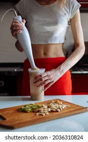 Woman With Hand Blender Making Sweet Banana Protein Shake