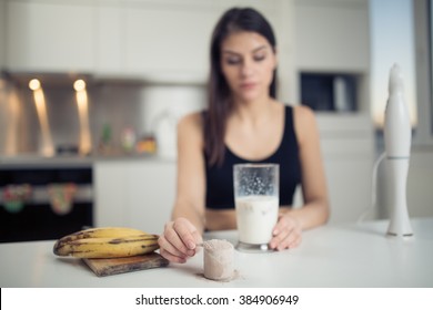 Woman With Hand Blender Making Sweet Banana Chocolate Protein Powder Milkshake Smoothie.Drinking Protein After Workout.Whey,banana And Low Fat Milk Sport Nutrition Diet After Gym.Healthy Lifestyle