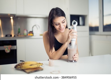 Woman With Hand Blender Making Sweet Banana Chocolate Protein Powder Milkshake Smoothie.Drinking Protein Shake After Workout.Whey,banana,low Fat Milk Sport Nutrition Diet After Gym.Healthy Lifestyle