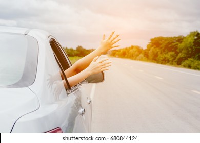 Woman hand in the car relaxing and happy traveler on the road