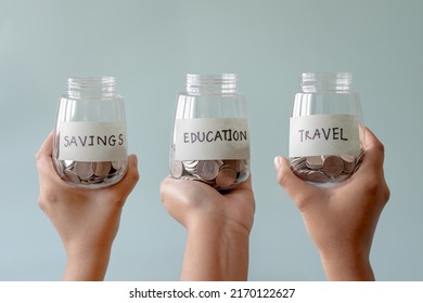 Woman Hand Carrying Coins Saving Jar Label Attach And Write In Education, Savings, Travel.