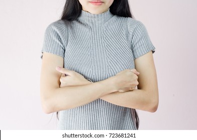 woman hand checking lumps on her breast for signs of breast cancer on crepe pink background, healthy lifestyle concept