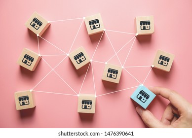 Woman hand choose wood blog with franchise marketing system in global network connection. Franchise business concept.