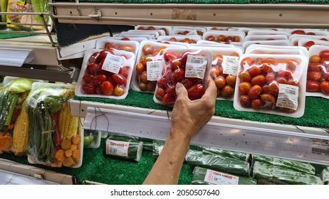 a woman hand choosing cherry tomatoes in supermarket. Jakarta, 1 october 2021.