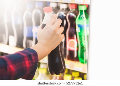 Woman Hand Choosing Cold Soft Drink Or Beverage On Shelves In Supermarket Store.