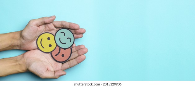 Woman hand choosing happy smile face paper cut, feedback rating and positive customer review, experience, satisfaction survey ,mental health assessment, world mental health day concept