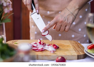 Woman Hand Chopping Radish With Kitchen Knife On Cutting Board. Cooking And Preparing Food And Vegetable Salad