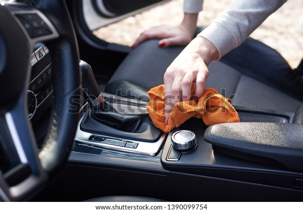 Woman hand clean car interior with microfiber cloth,\
close up