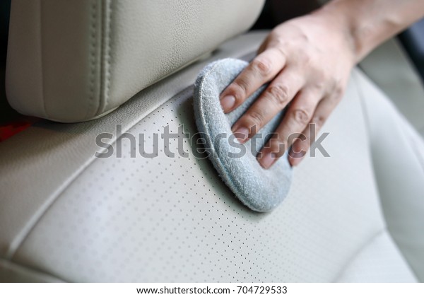 woman hand cleaning leather seat with soft\
fabric sponge waxing polished, car\
wash