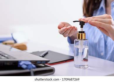 woman hand cleaning with sanitizer, cleaning antibacterial gel for hands, remote work on laptop at home concept - Powered by Shutterstock