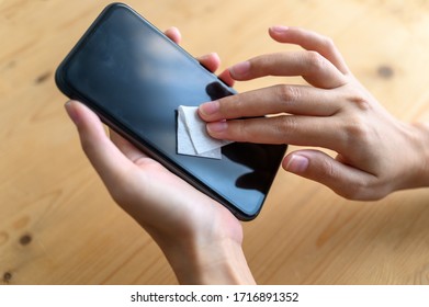 Woman Hand Cleaning Smartphone Display With Antibacterial White Tissue Or Disposable Wipes