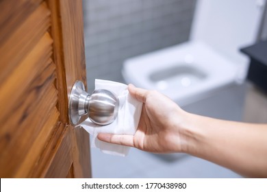 Woman Hand Cleaning Toilet Doorknob By Wet Wipe Tissue, Protection Coronavirus Or Corona Virus Disease (Covid-19) At Home. Clean Surface, Antiseptic, Lifestyle, Hygiene And New Normal Concept