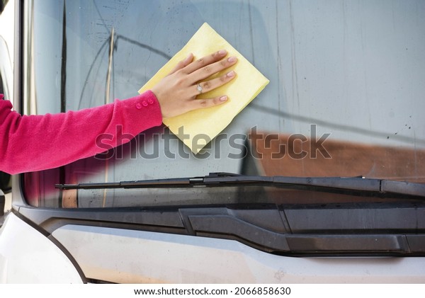woman hand cleaning truck\
windshield 
