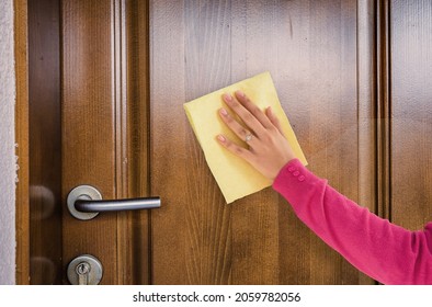 Woman Hand Cleaning Wooden Door 