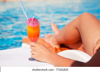 Woman hand with cocktail glass near swimming pool - Powered by Shutterstock