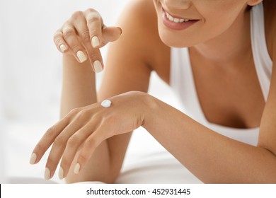 Woman Hand With Cream. Closeup Portrait Of Beautiful Happy Girl With Nude Makeup And Natural Manicure Nails Applying Cosmetic Moisturizing Hand Lotion On Soft Silky Skin. Beauty And Body Care Concept