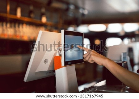 Woman hand doing process payment on a touchscreen cash register