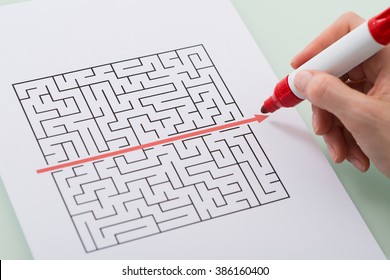 Woman Hand Drawing Straight Red Line Over Maze With Red Marker