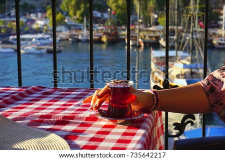  woman hand drinking tea at marina of Antalya                              