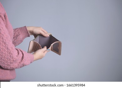 Woman Hand Empty Wallet On Grey Background