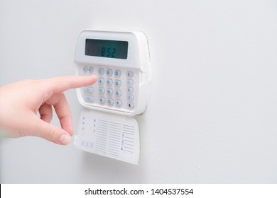 Woman Hand Entering Alarm System Password Of An Apartment, House Of Business Office. Surveillance And Protection Console Against Rubbery And Thief