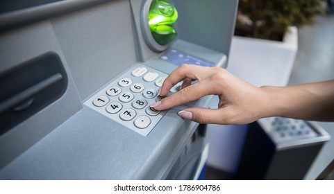 woman hand entering personal identification number on ATM