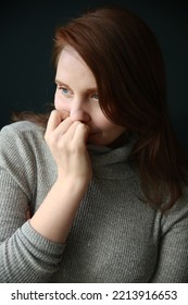 Woman With Hand To Face Wearing Grey Turtleneck Shirt