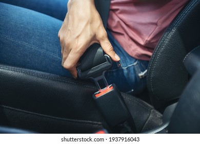 woman hand fastening a seatbelt in the car, Cropped image of a woman sitting in car and putting on her seat belt, Safe driving concept.