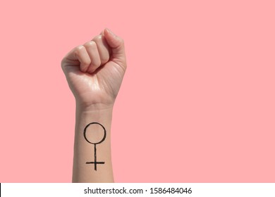 A Woman Hand And Feminist Sign Tattoos On Her Hand Isolate On Pink Background 