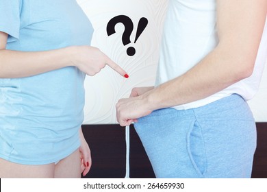 Woman hand finger pointing in direction of male genitalia while man holds open underwear and showing his penis. Question of impotence or sexual organ size . Peny and medical or psychological problem