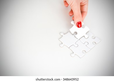 Woman Hand Fitting The Right Piece Of Puzzle Suggesting Business  Networking Concept